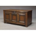 An oak coffer, 17th century, the two plank top above fluted frieze and three panel front, on stile