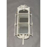 A Victorian white-painted mirrored wall shelf, the crest with floral and fern decoration, over three