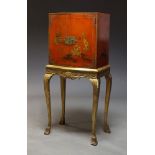 A Chinoiserie red lacquer and parcel gilt cabinet on stand on stand, mid 20th Century decorated with