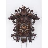 A Black Forest oak carved cuckoo wall clock, late 19th Century, the architectural case and gable