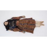 A Victorian papier-mache head doll, circa. 1840, with regional costume, painted black hair, set with