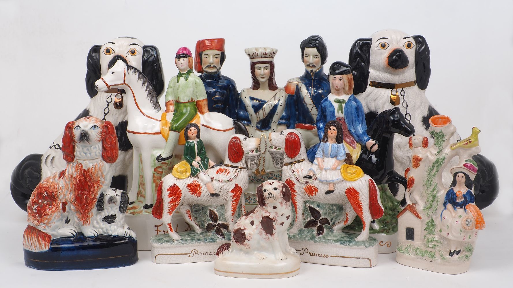 A collection of Staffordshire figural groups and figures, late 19th century and later (some