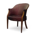 A Regency mahogany bergere armchair, the curved back with maroon fabric upholstery and brass stud