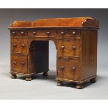 A Victorian mahogany kneehole desk, the rectangular top with raised three quarter gallery, above