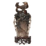 A Chinese quartz vase and cover, 20th century, the body deeply carved with leaves and floral blooms,