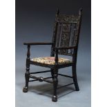 A stained oak armchair, early 20th Century, with slatted back, having floral carved decoration,