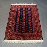 A Turkoman pattern rug, with rows of guls in blue field, 179cm x 131cmPlease refer to department for