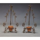 A pair of wrought iron hanging planters, early 20th Century, with open scrollwork decoration, each