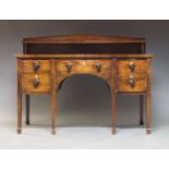 A Regency mahogany serpentine sideboard, the top with raised pediment back, having one shelf, over
