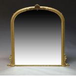 A gilt framed overmantle mirror, late 20th Century, of arched form with carved foliate decoration,
