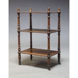 A Victorian mahogany three tier whatnot, with turned finials and supports, raised on leather