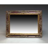 A red painted and gilt overmantle mirror, late 20th Century, of rectangular form with scrolling