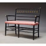 An Arts and Crafts ebonised and parcel gilt two seat settee, with spindle backrest, above