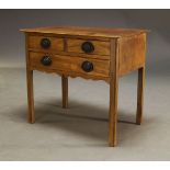 A George IV mahogany lowboy, the rectangular top above three drawers and shaped apron, raised on