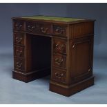 A George III style pedestal desk, late 20th Century, the rectangular top inset with green