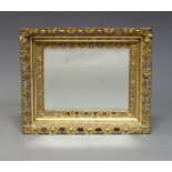 A gilt wood wall mirror, late 20th Century, of rectangular form with pierced scrolling foliate frame