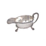 A 20th century Egyptian 800 silver sauce boat, 1916-1946, raised on three trefoil shouldered paw