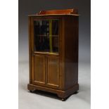 An Edwardian mahogany and glazed side cabinet, the top with raised back above, glazed door enclosing