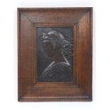A bronze shallow relief portrait plaque, 19th Century, depicting a female saint or maiden in an