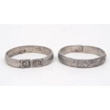 A pair of Chinese white metal bangles, 20th century, decorated with flowering lotus blooms, ***