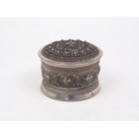 A Burmese white metal circular box and cover, early 20th century, repousse decorated with animals