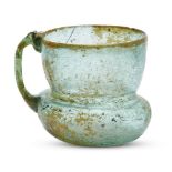 A bluish-green glass cup, Iran, 9th-10th century, the wide flaring mouth with a rounded rim on a