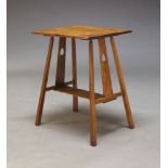An Arts and Crafts oak side table, in the manner of Liberty & Co. the rectangular top on square