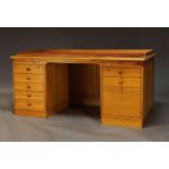 A pine kneehole desk by Heal's, the top with tan leather writing surface and three quarter gallery