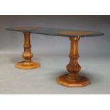 A glazed pedestal dining table, late 20th Century, the rounded rectangular glass top on two turned