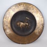 A large modern brass charger, 20th Century, with central decorative scene of a nude female riding