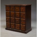 A modern stained pine chest, of recent manufacture, with sixteen short drawers, raised on plinth