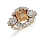 A topaz and diamond cluster ring, the central cut-cornered square pale orange topaz between old-