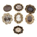 A group of seven 19th century gilt-mounted mourning brooches, comprising: four enamel examples,