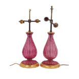 A pair of glass table lamps, 20th century, of fluted baluster form, the mottled cranberry glass