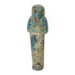 An Egyptian bright blue glazed composition shabti of typical form with black glazed details, holding