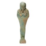 An Egyptian green glazed composition shabti, the uninscribed body depicted holding a pick and hoe