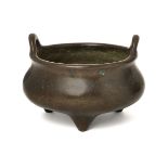 A Chinese bronze two-handled tripod censer, 18th/19th century, of typical bombe form, the base