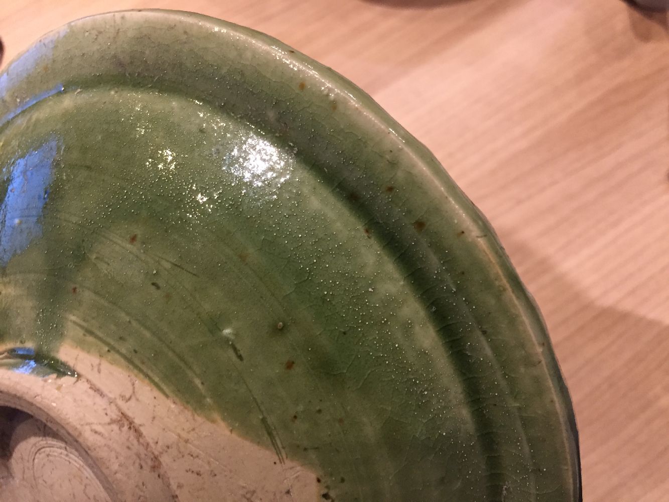 A Vietnamese stoneware green-glazed dish, 14th century, with pinched petal design to the interior - Image 5 of 13