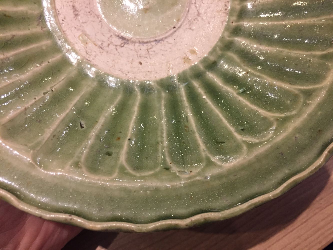 A Vietnamese stoneware green-glazed dish, 14th century, with pinched petal design to the interior - Image 9 of 13