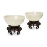 A pair of Chinese pale celadon jade bowls, 19th century, each carved with deep sides and a