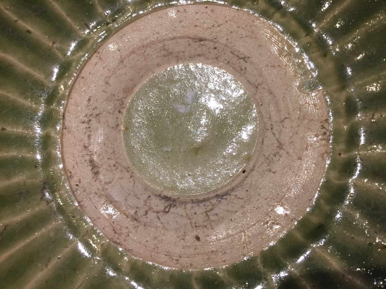 A Vietnamese stoneware green-glazed dish, 14th century, with pinched petal design to the interior - Image 11 of 13