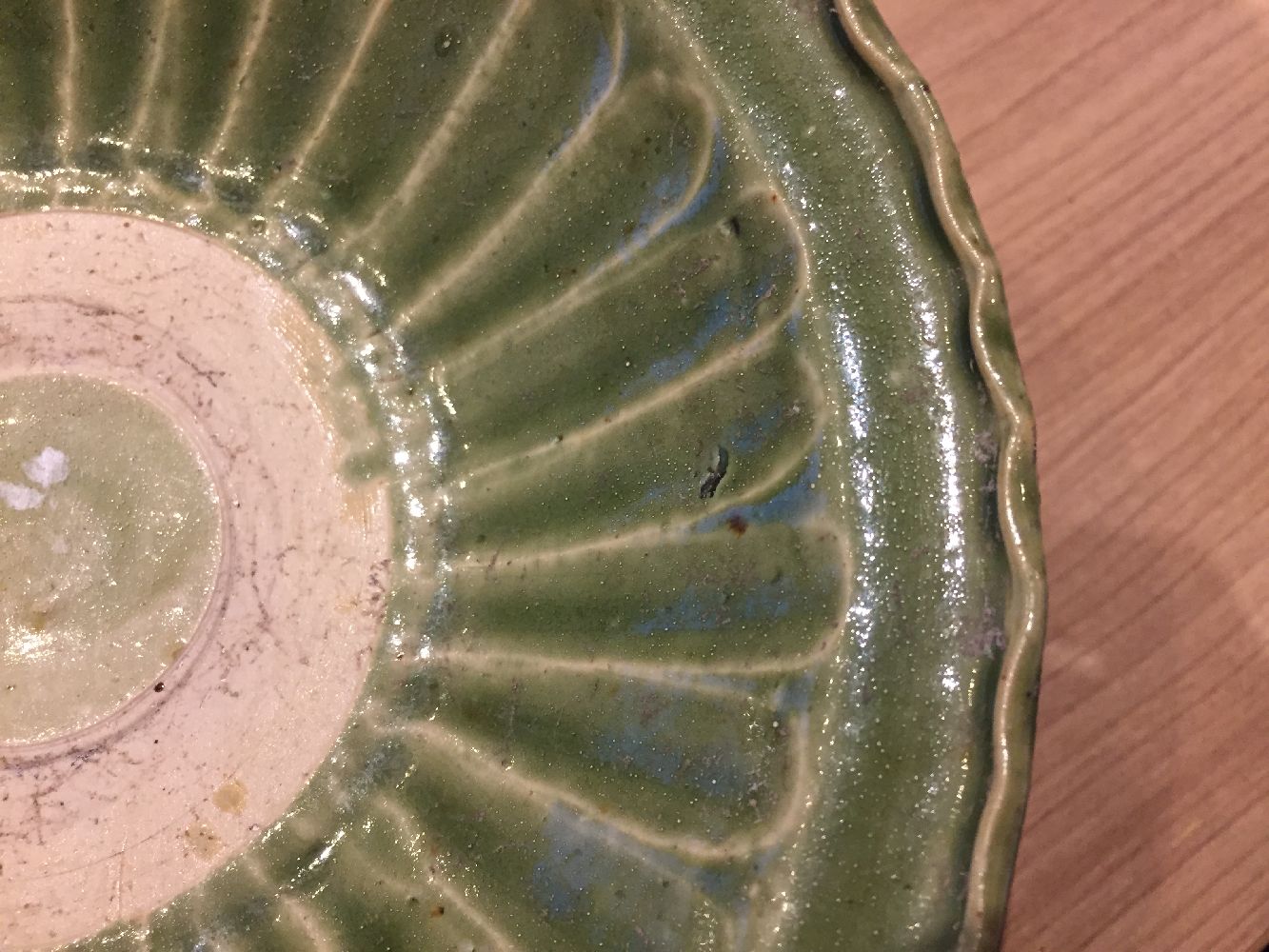 A Vietnamese stoneware green-glazed dish, 14th century, with pinched petal design to the interior - Image 8 of 13