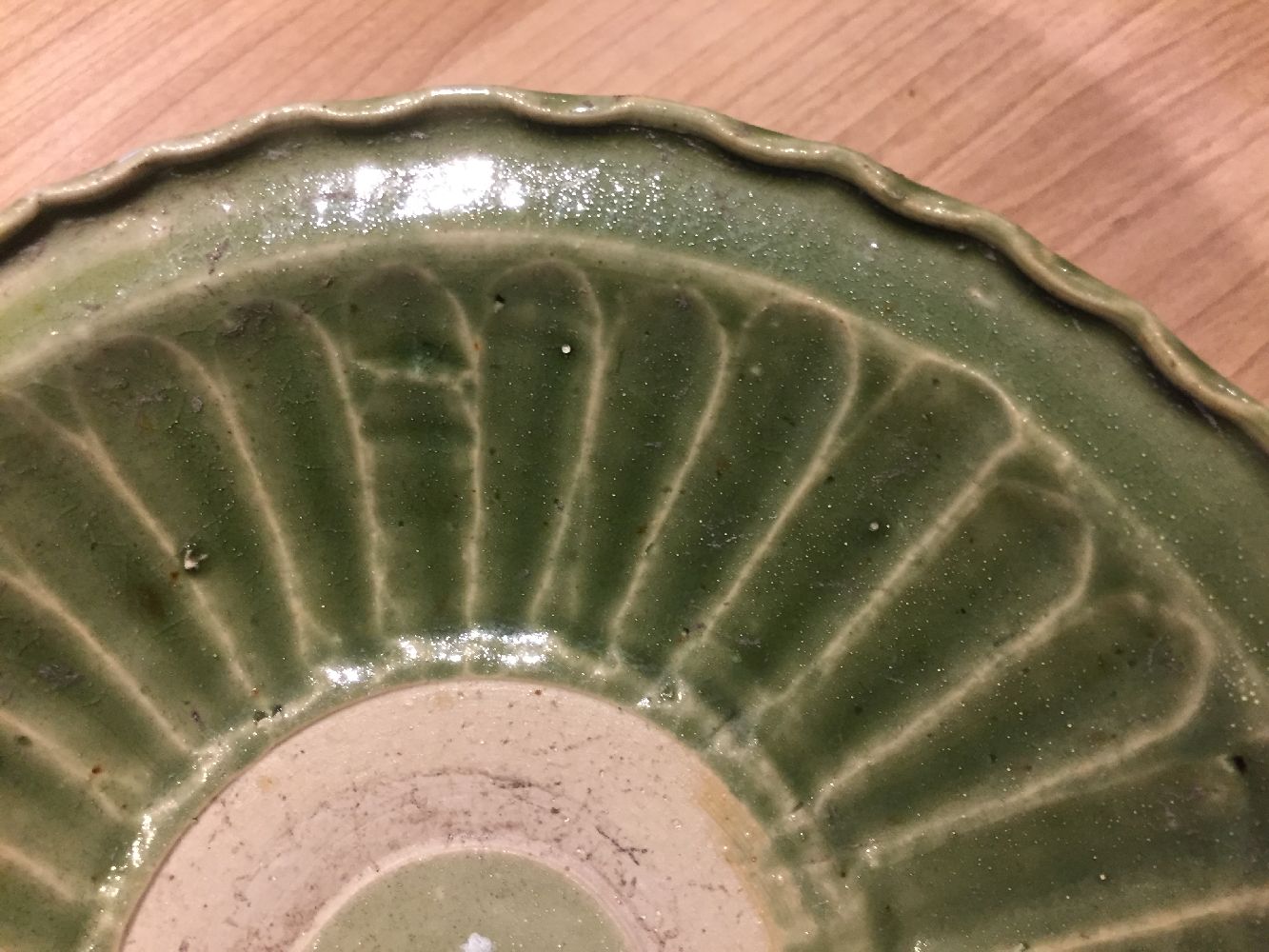 A Vietnamese stoneware green-glazed dish, 14th century, with pinched petal design to the interior - Image 7 of 13