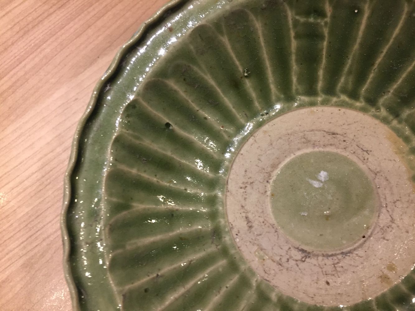 A Vietnamese stoneware green-glazed dish, 14th century, with pinched petal design to the interior - Image 10 of 13