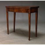 A George III mahogany serpentine card table, the fold-over top enclosing green baize lined playing