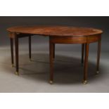 A George III style mahogany extending dining table, late 19th, early 20th Century, the oval top with