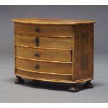 A Continental walnut and crossbanded miniature chest of drawers, 19th Century, of bow front form,