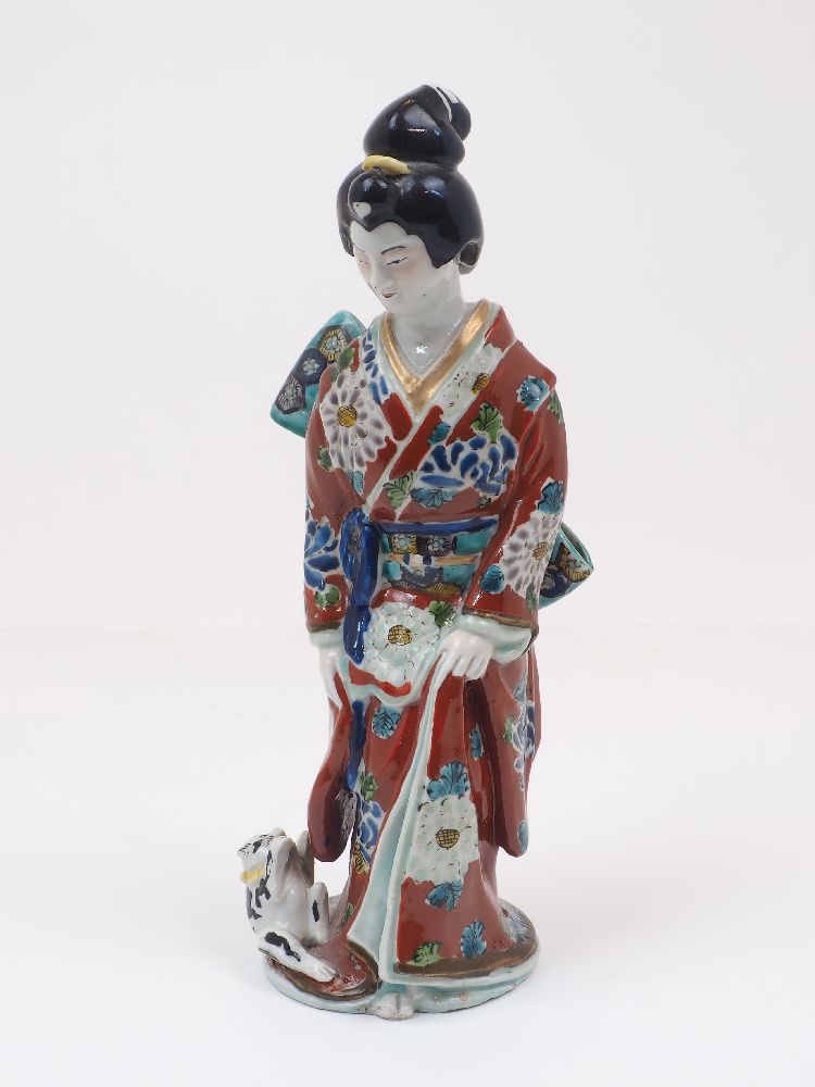 A Japanese porcelain figure of a geisha, late 19th/early 20th century, modelled wearing a kimono,