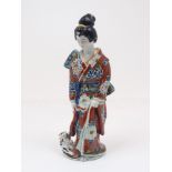A Japanese porcelain figure of a geisha, late 19th/early 20th century, modelled wearing a kimono,
