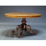 A Victorian figured walnut tilt top loo table, the oval quarter veneered top on baluster form